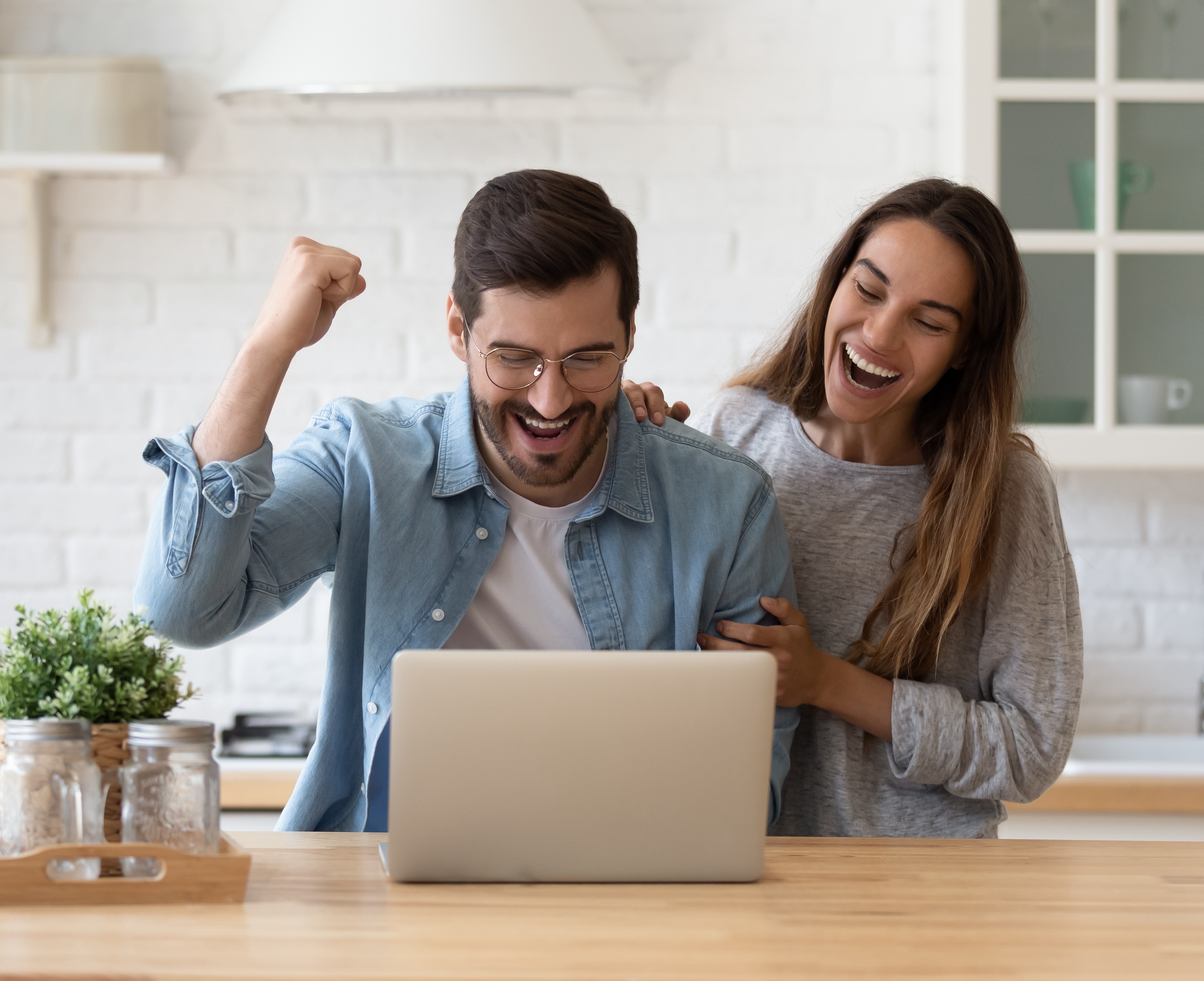Family reading e-mail from bank on laptop celebrate loan approval Family reading e-mail from bank on laptop celebrate loan approval